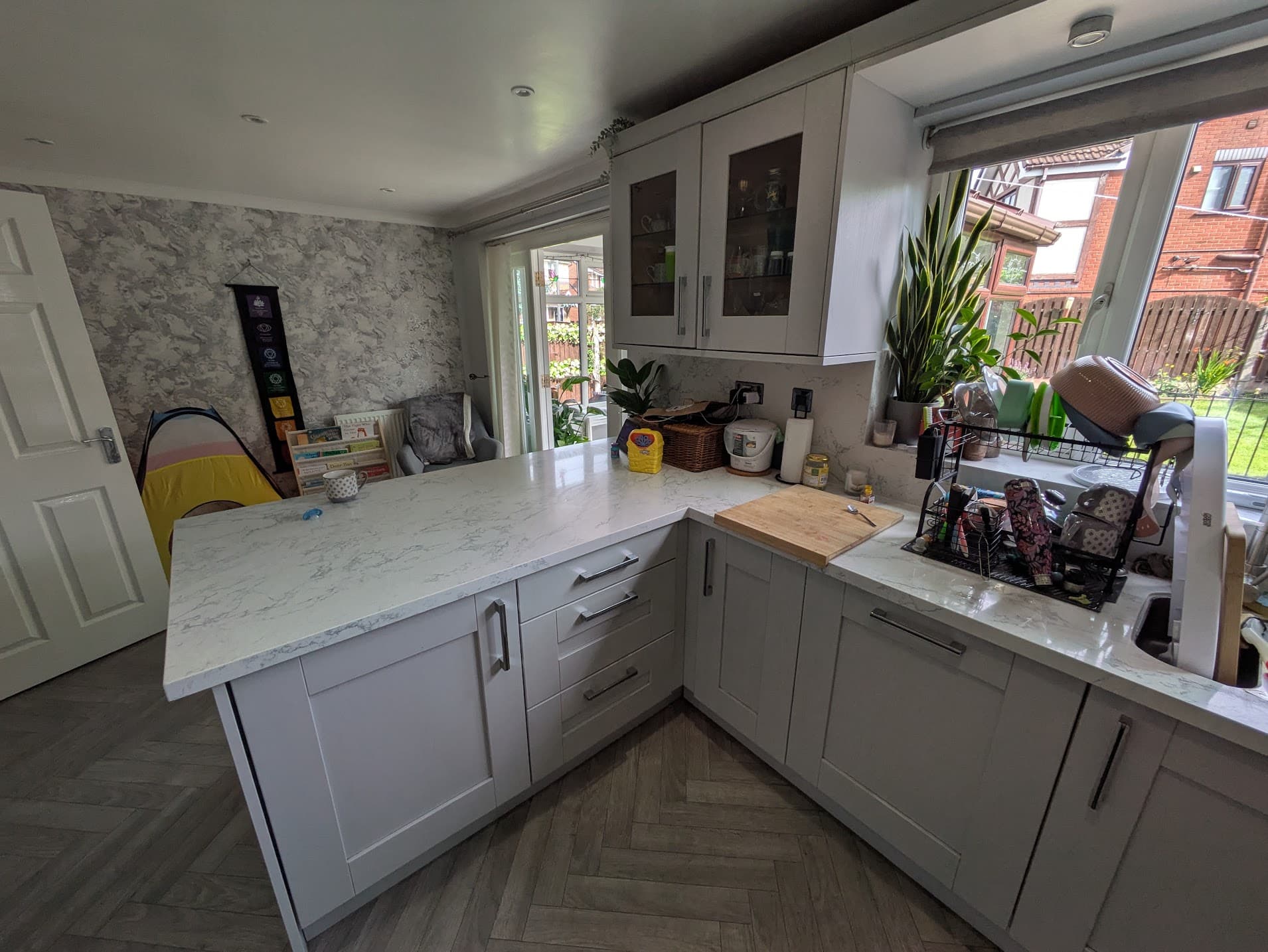 Vinyl-wrapped kitchen door with peeling laminate near the dishwasher — Greater Manchester home before workshop respray